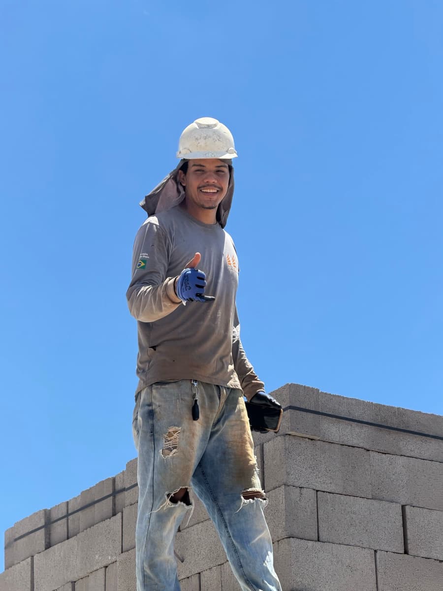 Pedreiro sorrindo com blocos de concreto